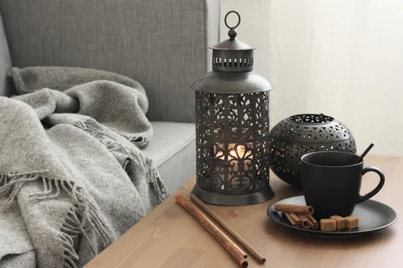 Gemütliche Ecke mit Laterne und Tasse auf dem Tisch